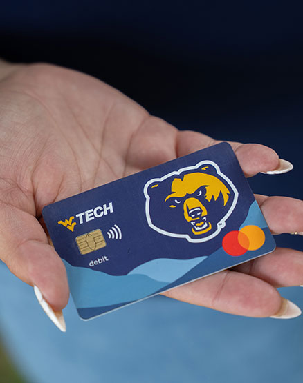 A hand holding a WVU Tech debit card