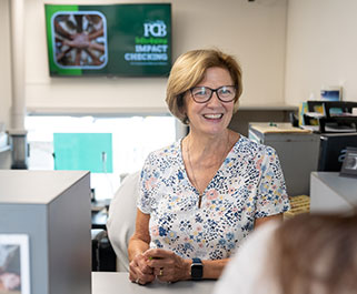 woman teller smiling and talking with a customer