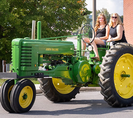 Two people driving a tractor