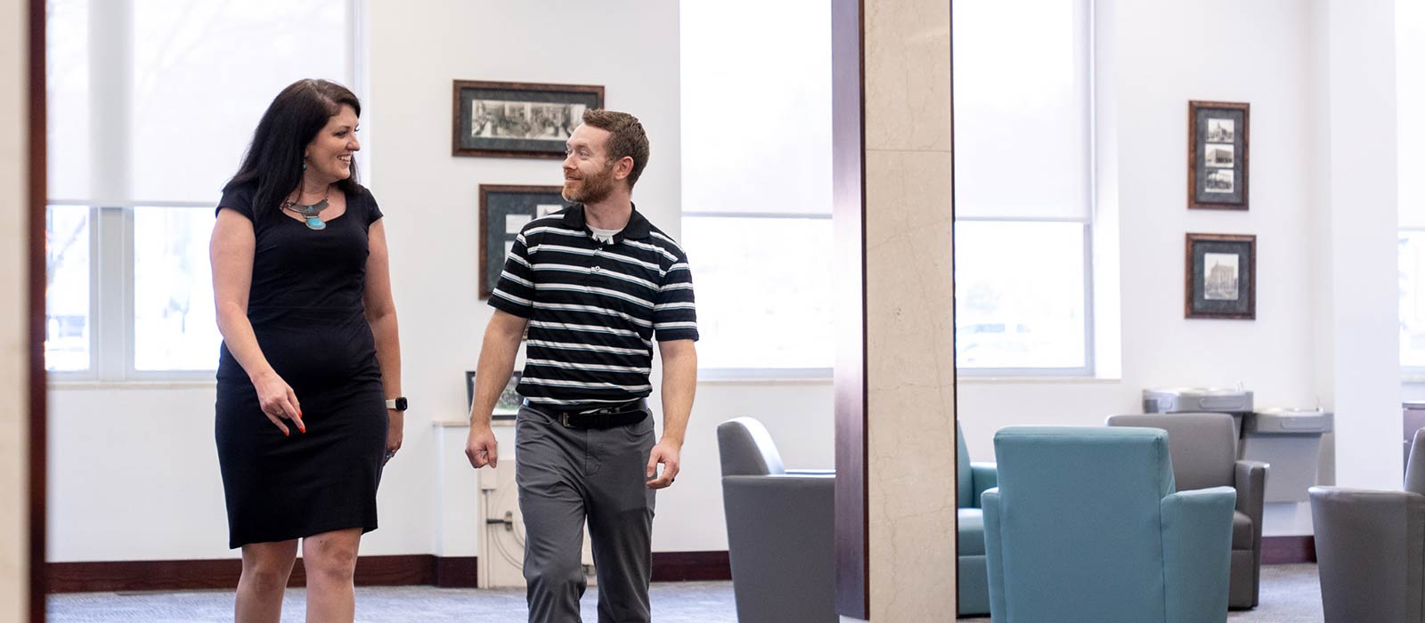 Two people walking in bank lobby