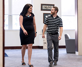 Two people walking and talking in the bank lobby