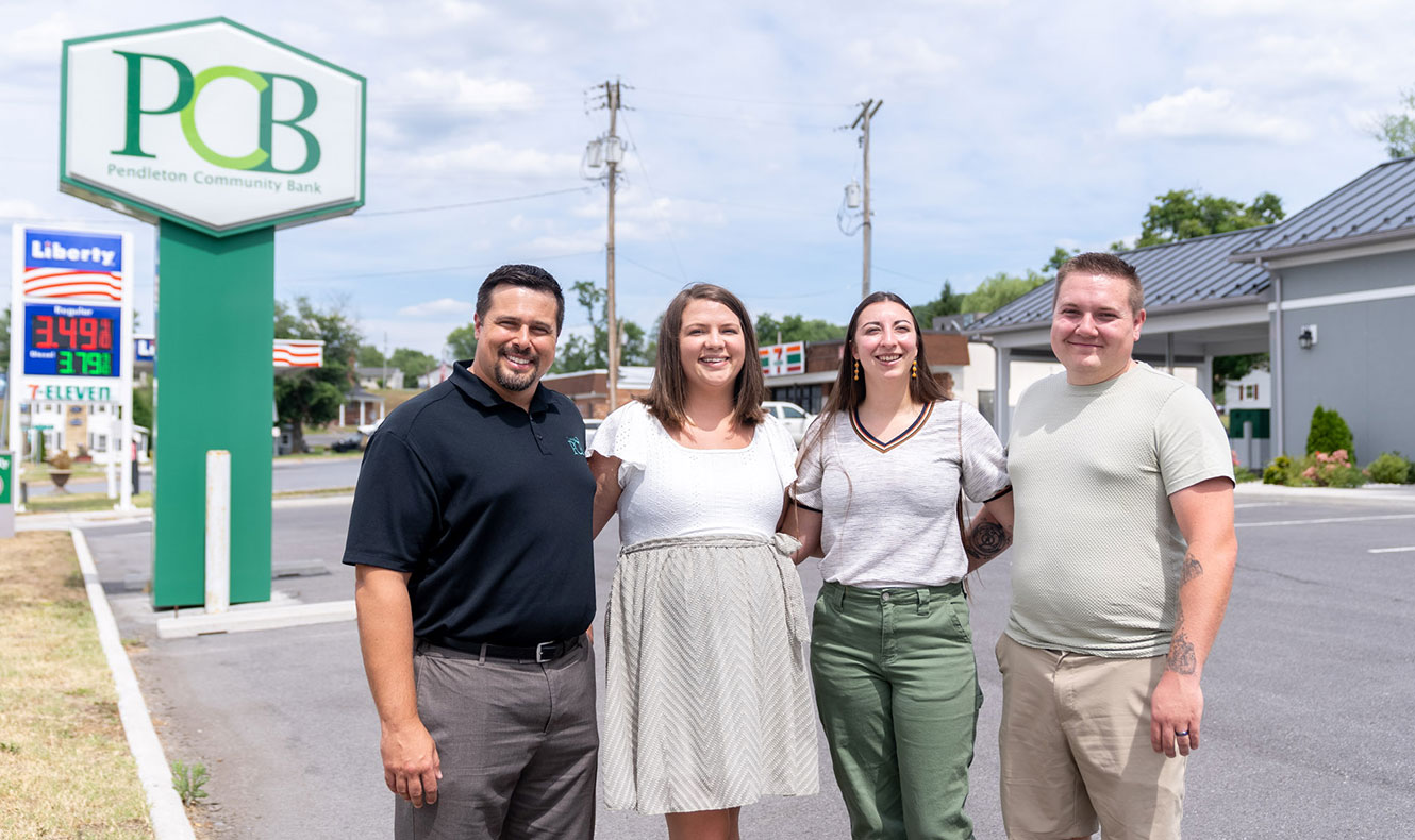 Four people outside posing for photo