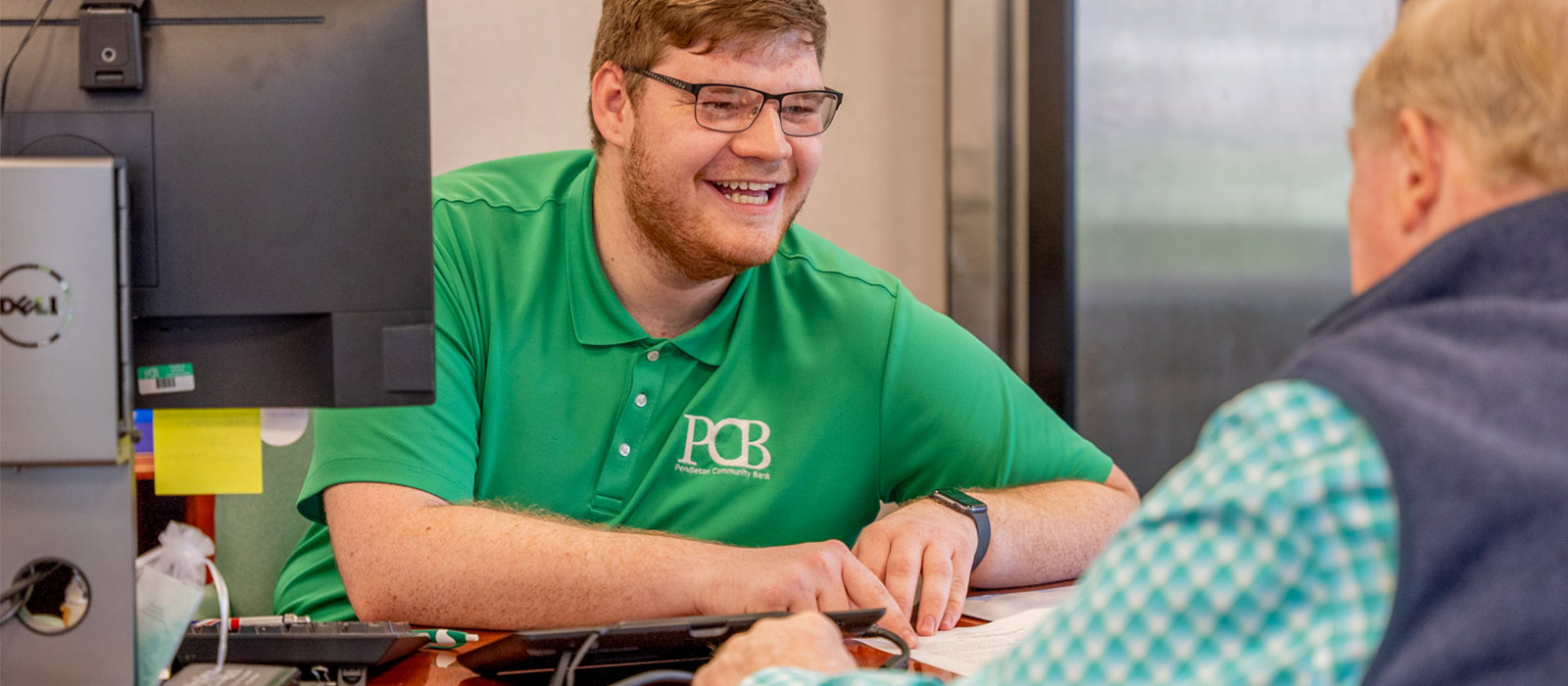 man smiling and talking with another man