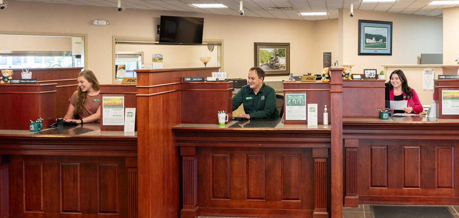 3 tellers smiling behind the teller line