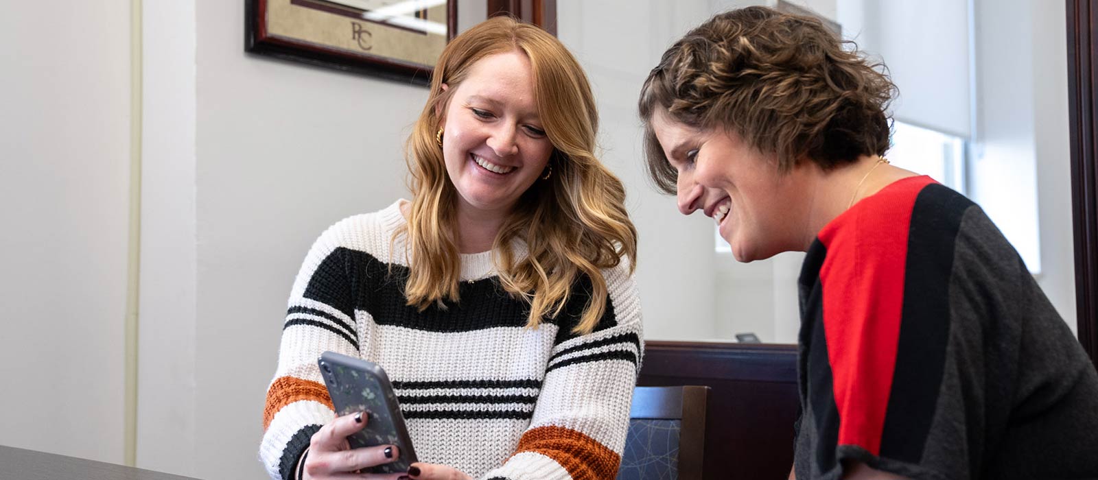 Two people looking at a phone