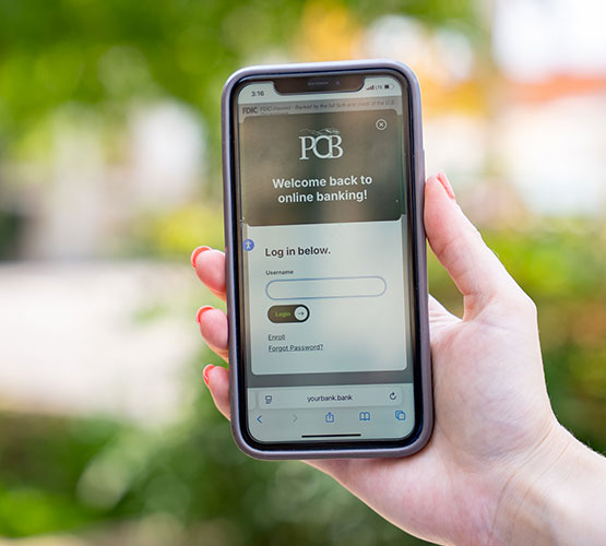 PCB Mobile login on phone being help by woman's hand