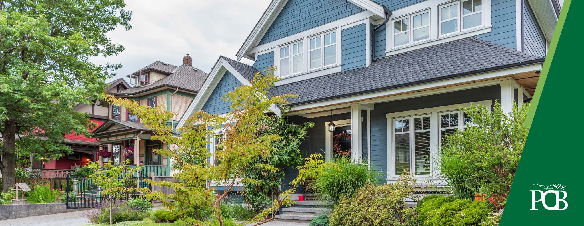 medium blue 2-story house with lots of green shrubbery