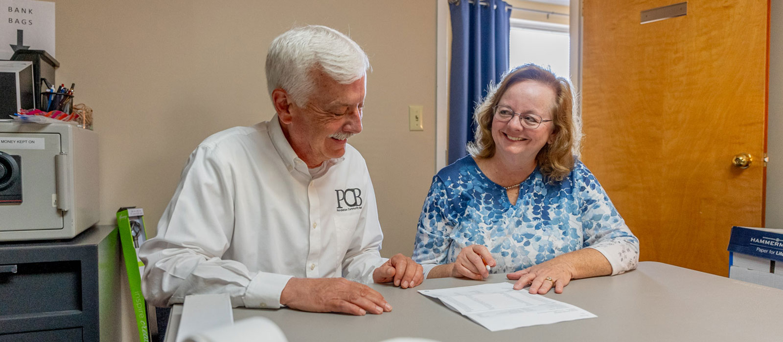 Two people talking and completing paperwork