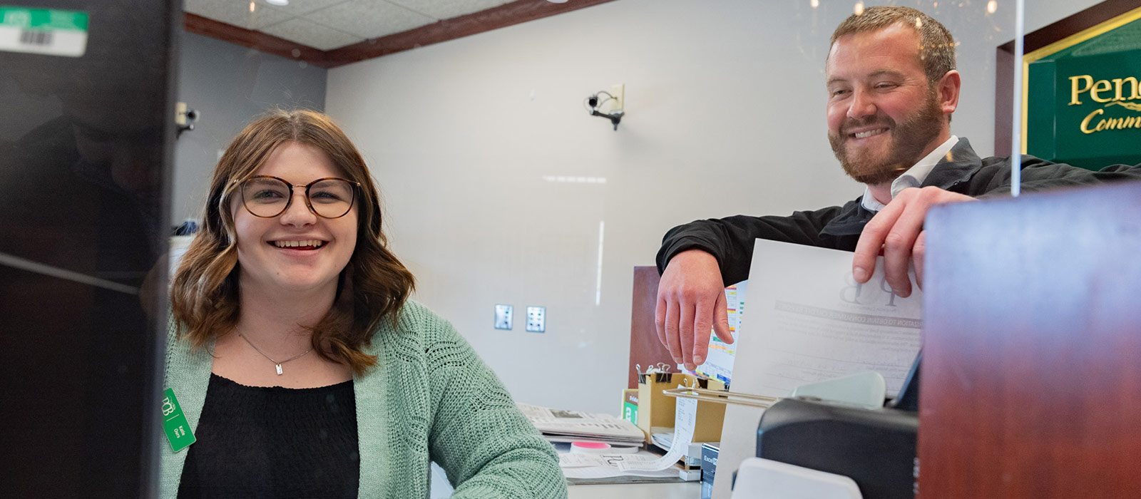 man and woman behind teller line smiling and talking