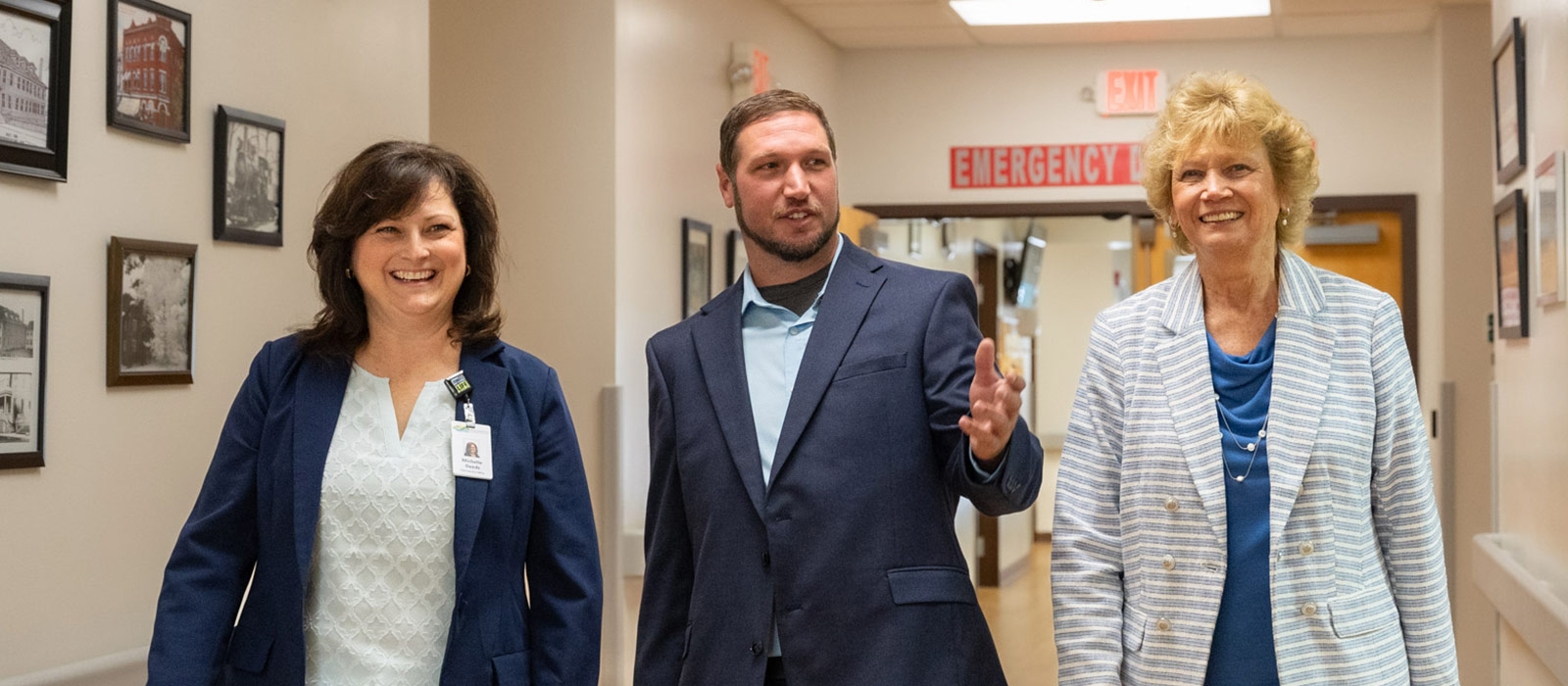 Three people walking through a hospital