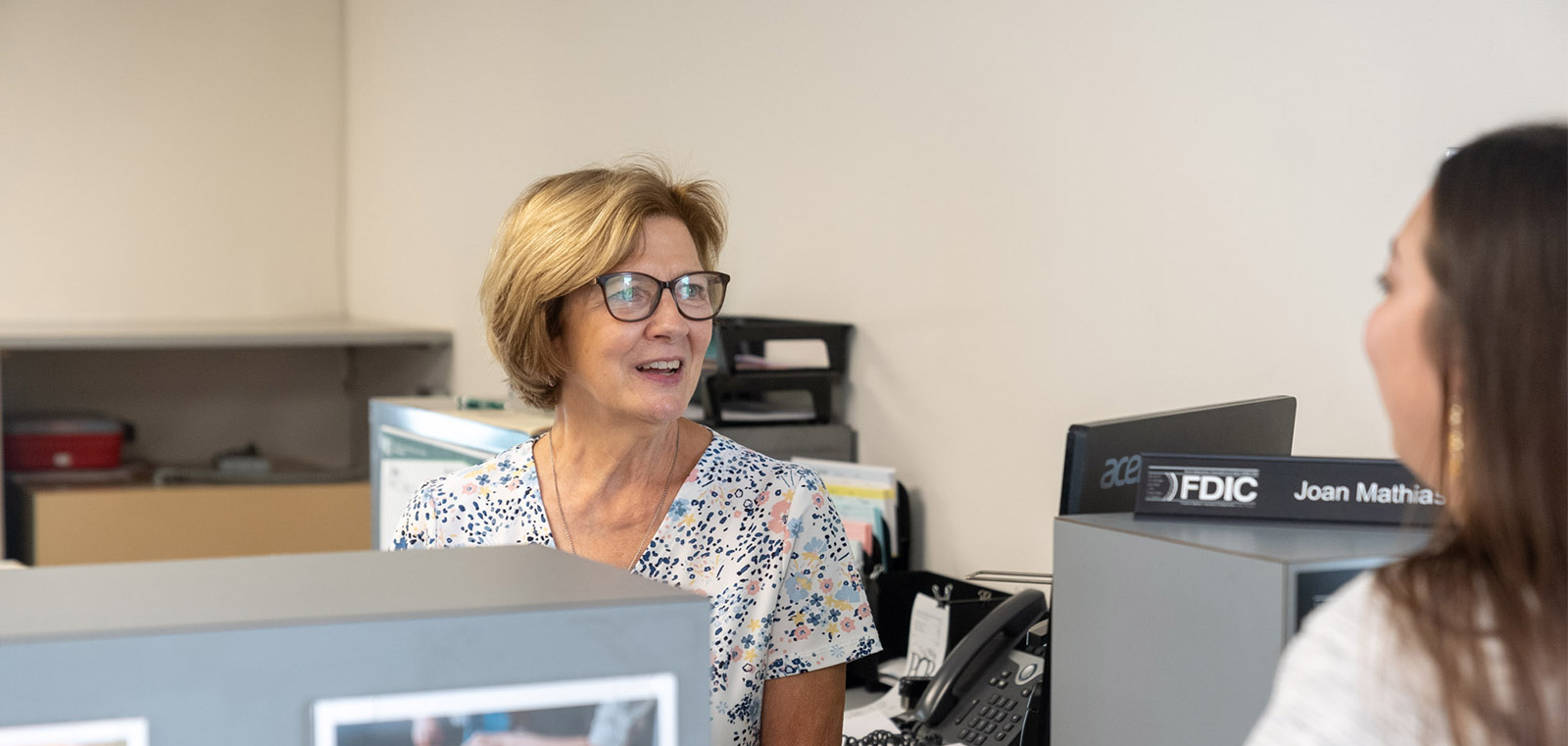 woman teller smiling and talking with a customer