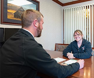 Two people talking at a desk