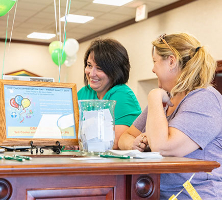 Two people talking in the bank lobby