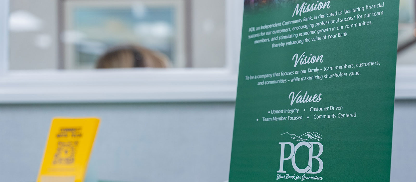 PCB's mission, vision, and values on a small pull up banner