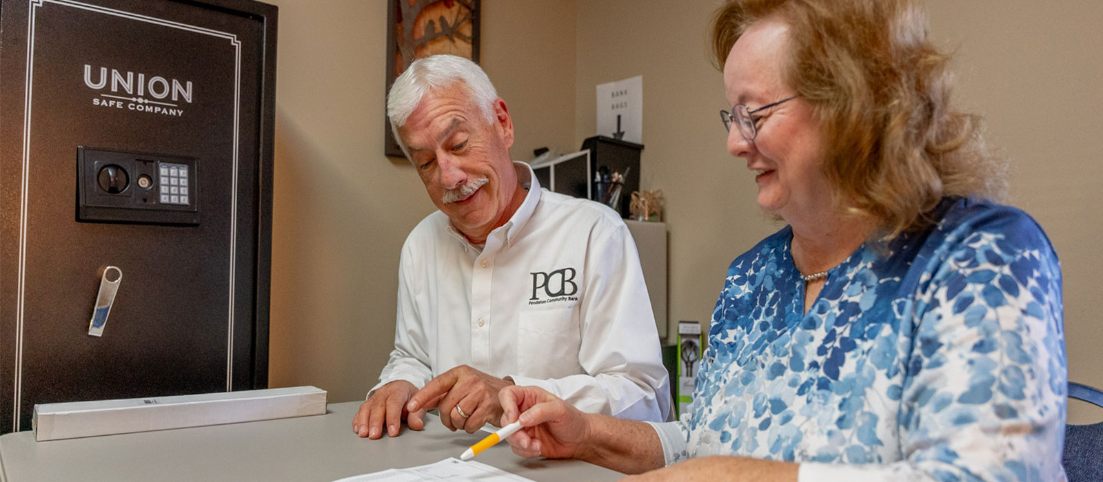 man team member and customer looking at a paper and talking