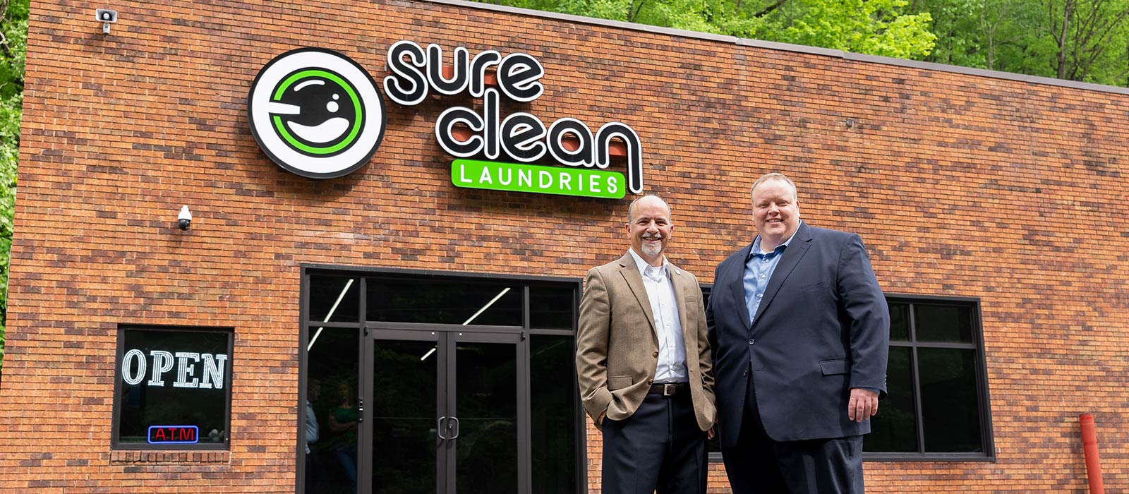 Two people outside a laundromat